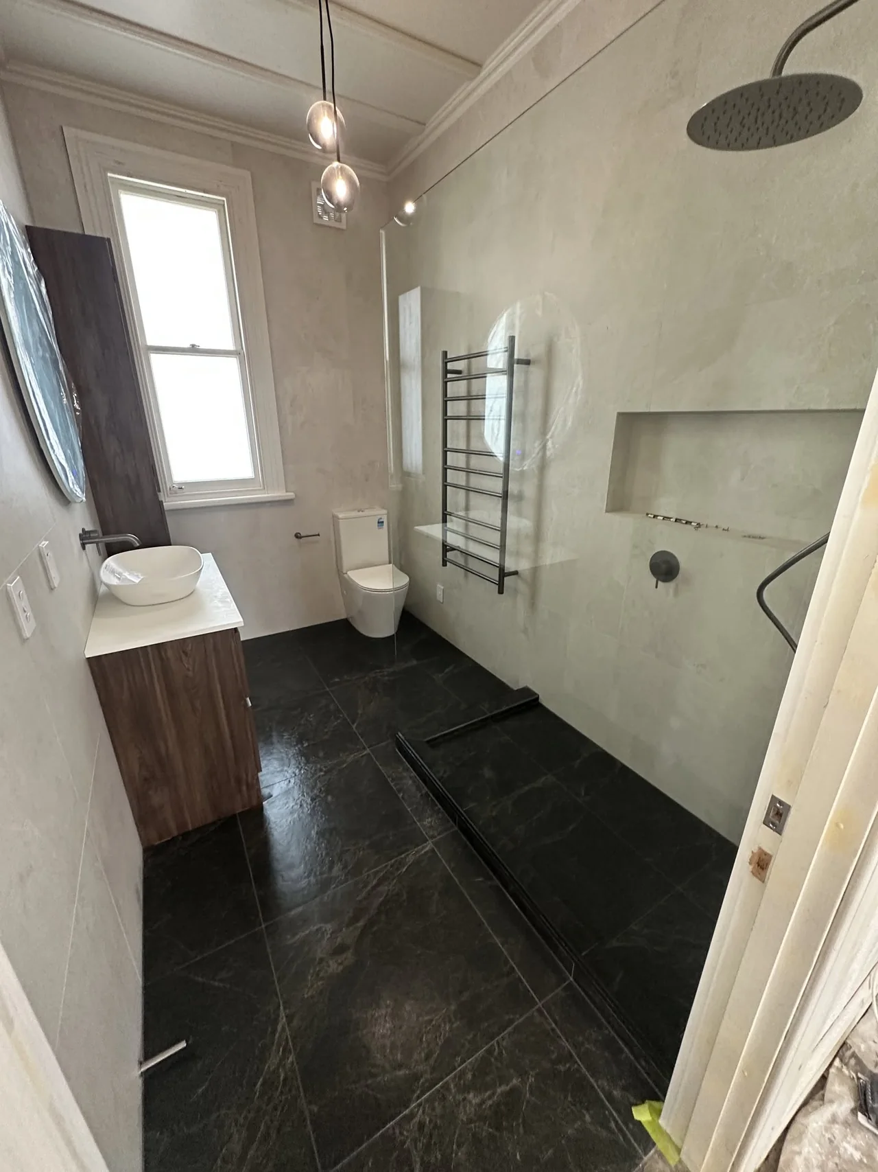 Bathroom with walk-in shower, dark floor tiles and wall-mounted vanity