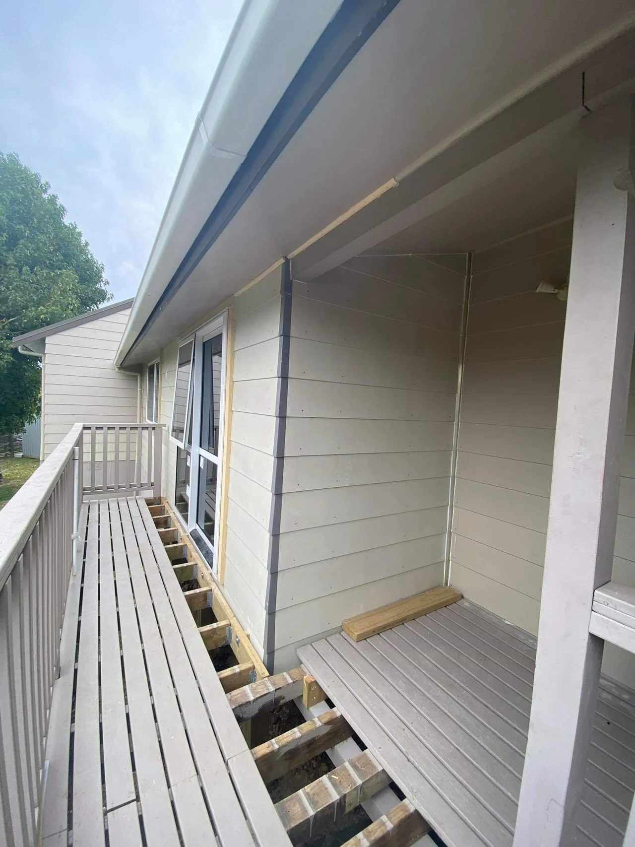 New weatherboards and glazed doors being fitted beside the verandah
