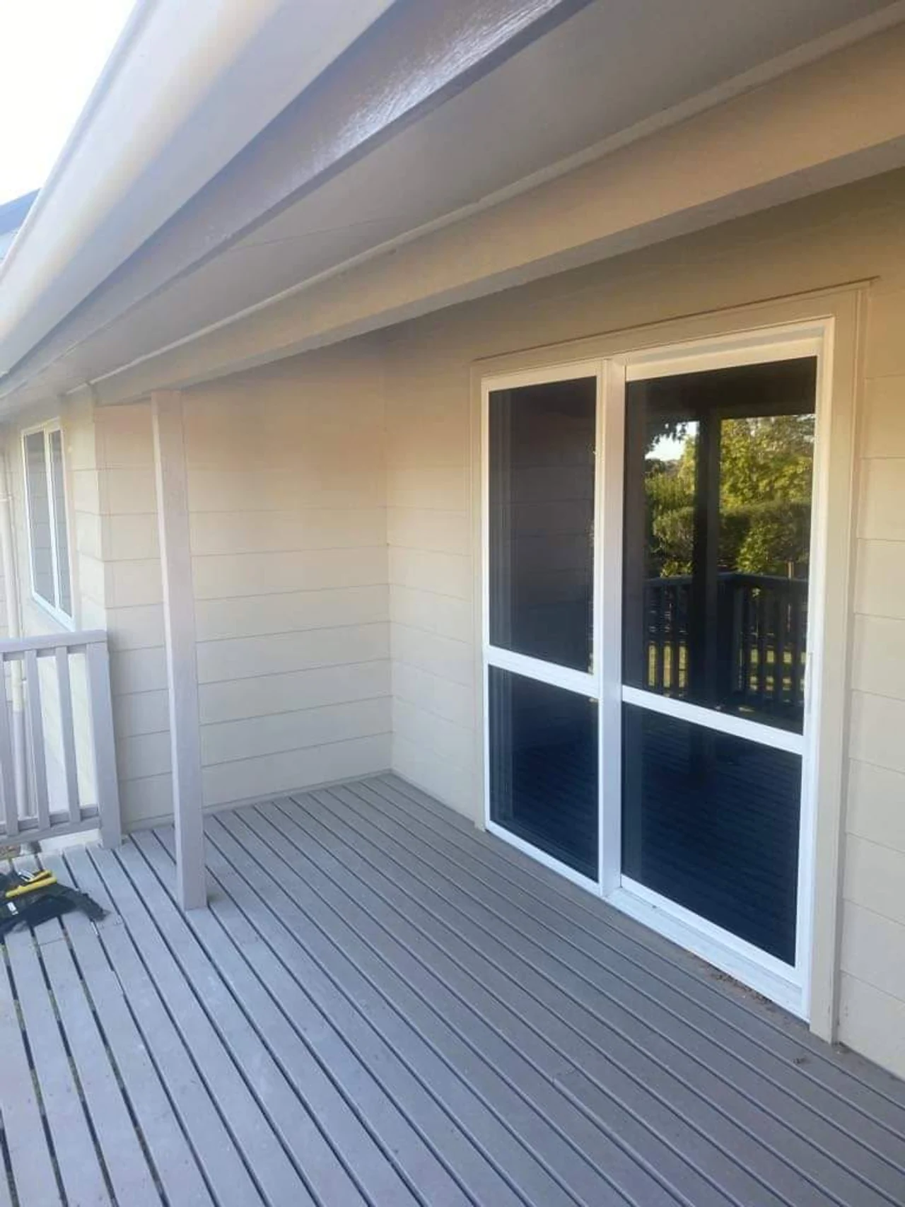 New glazed doors and weatherboard cladding beside a verandah