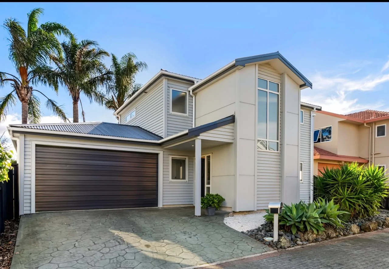 Re-clad home with a weatherboard exterior and dark garage door