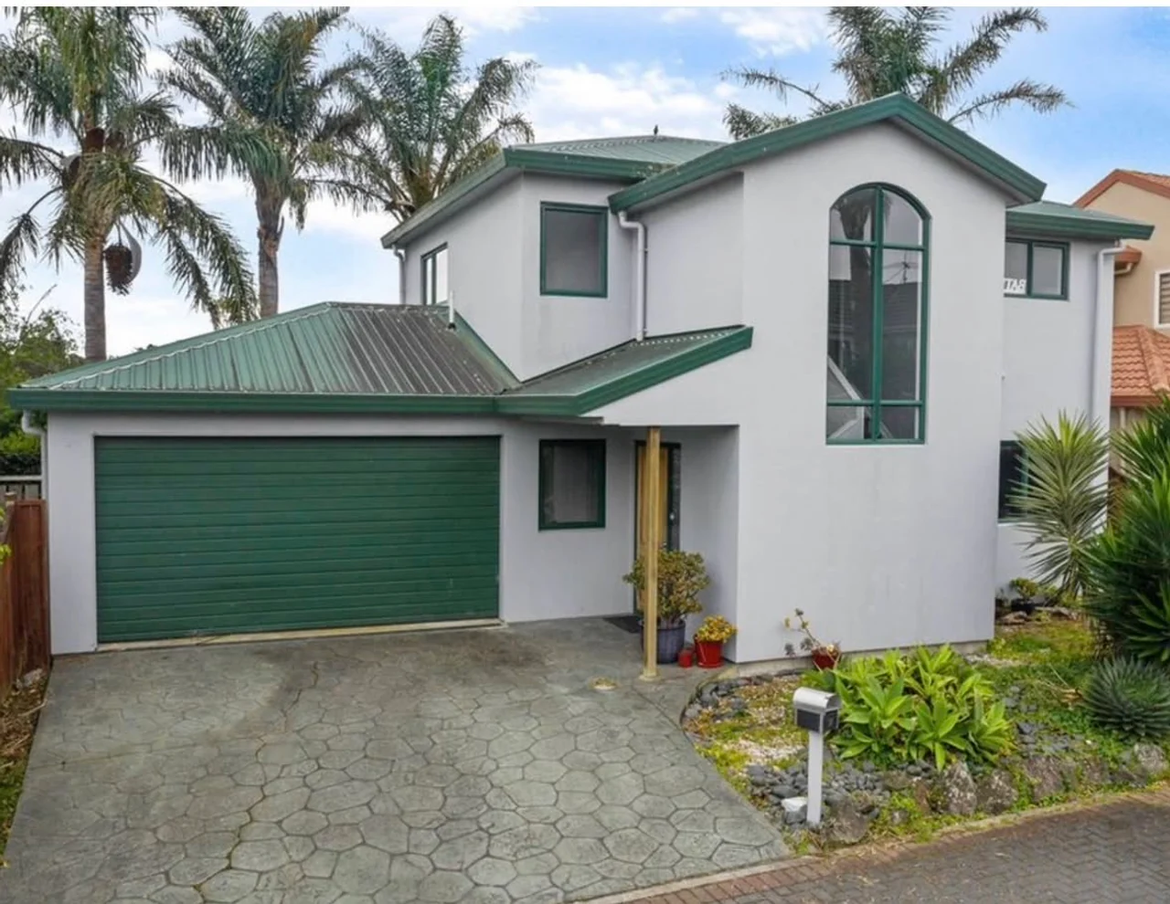 Home before re-cladding, with plaster exterior and green joinery