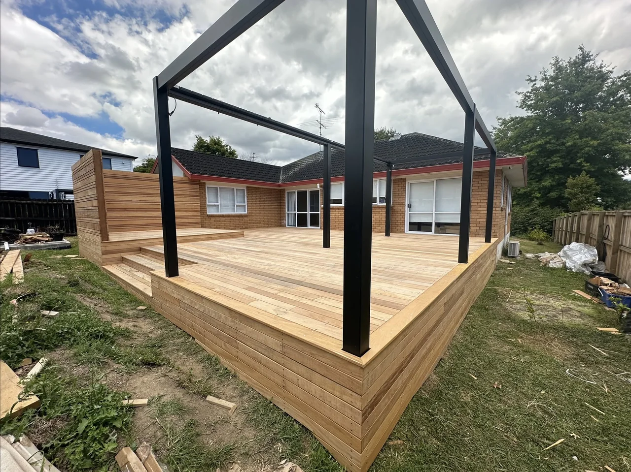 Dark pergola frame above a newly built timber deck