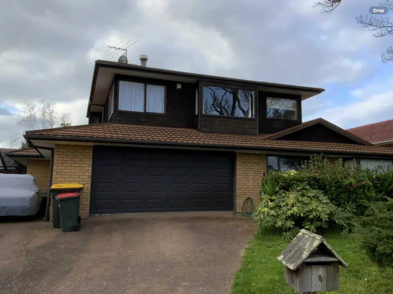 The same home before work, with dark brown upper cladding and original windows