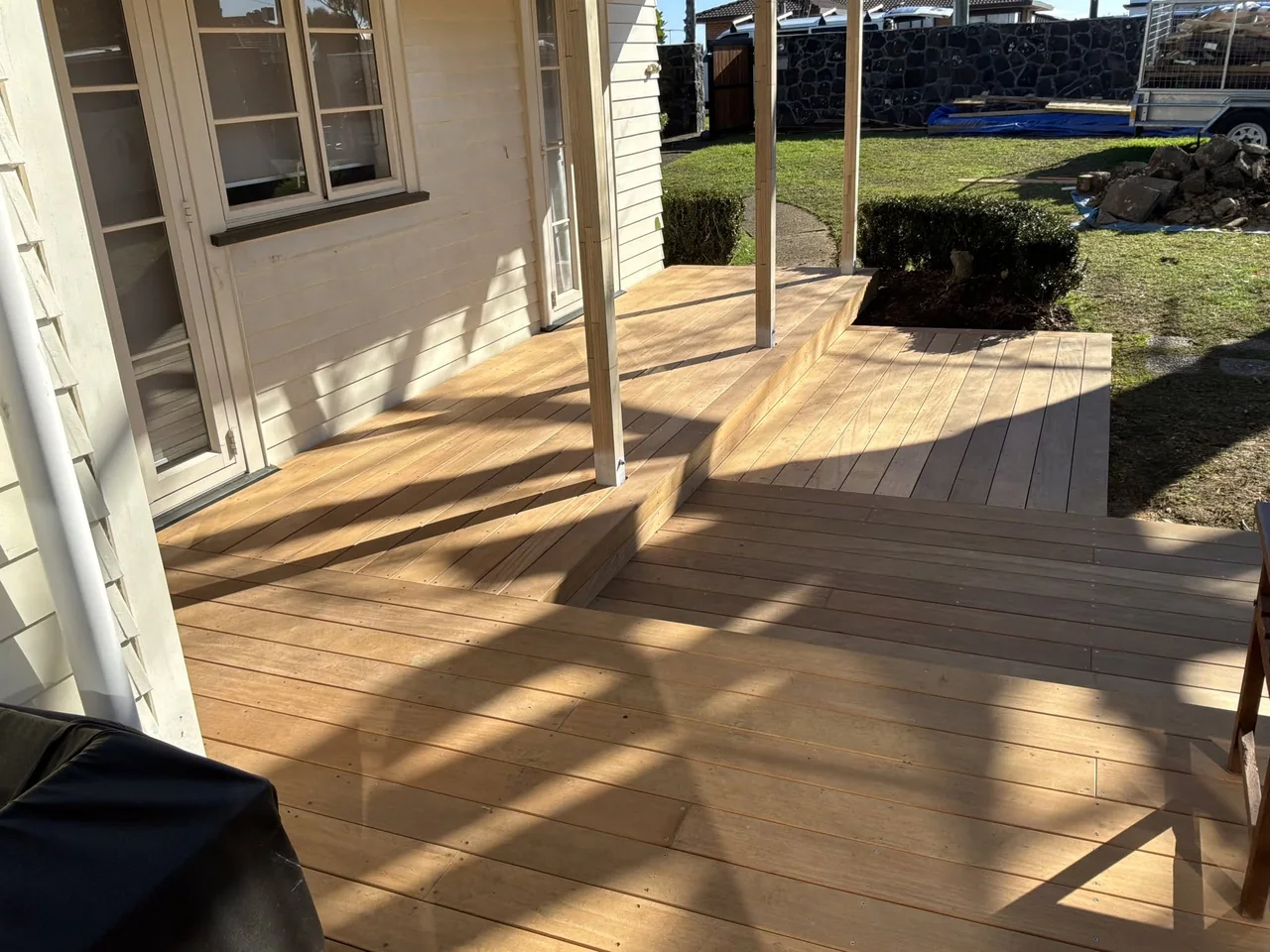 Sunlight across timber decking beneath a covered verandah